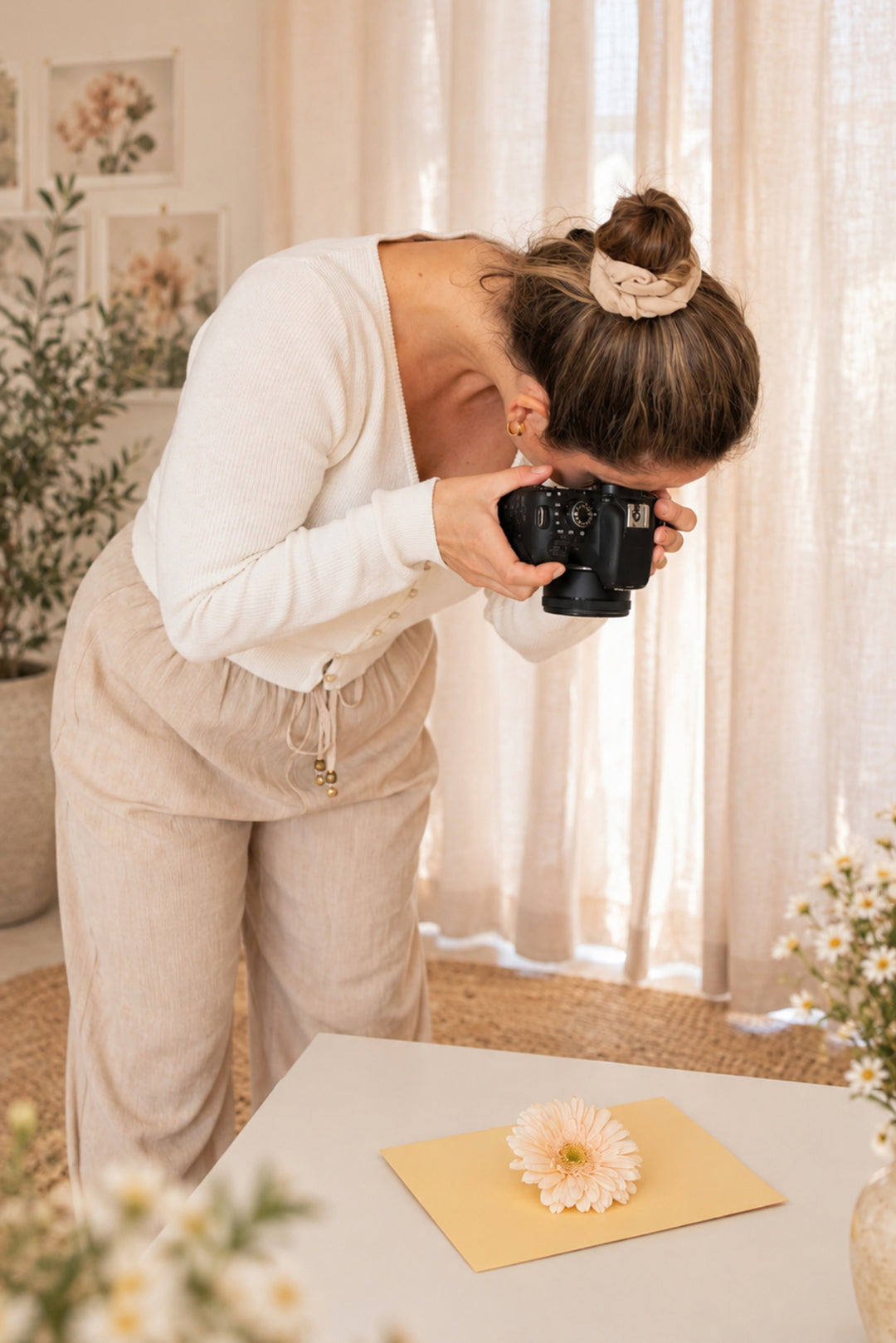 Therese Håkansson, artist and founder of BabyBlossom Art Design, photographing a real flower to create nature-inspired wall art combining flower photography with hand-drawn animal illustrations.